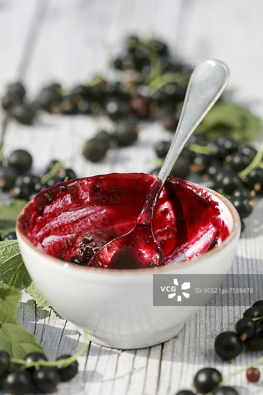 小碗里带勺子的黑加仑果酱图片素材