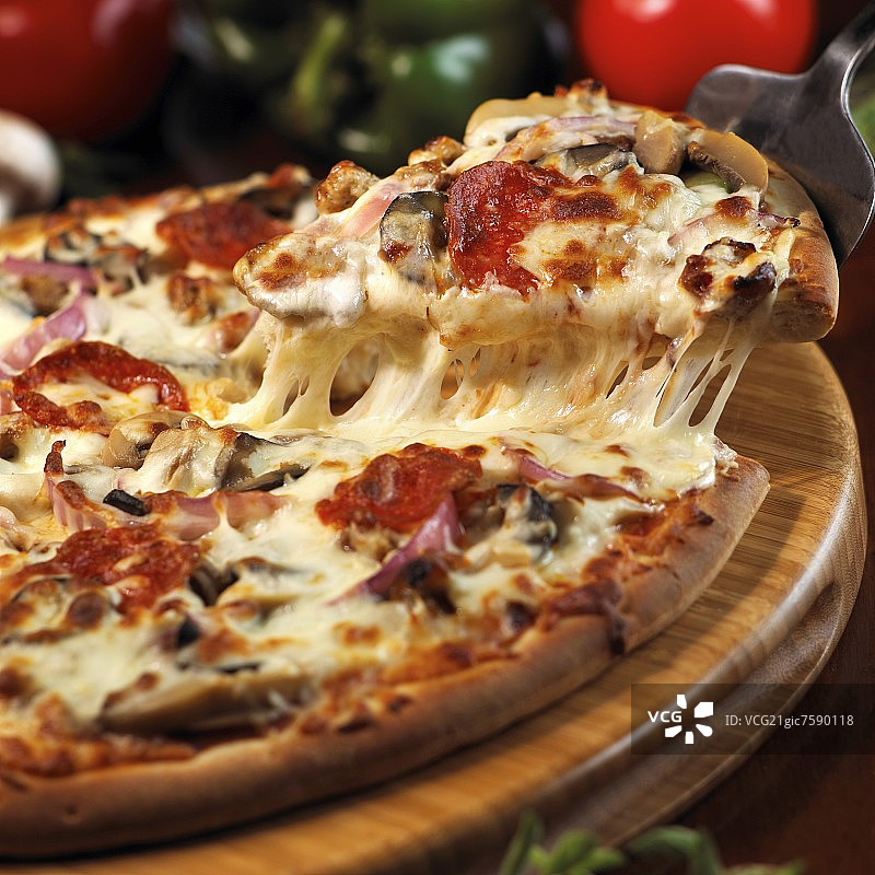 用铲子移除意大利辣香肠、洋葱和蘑菇披萨图片素材