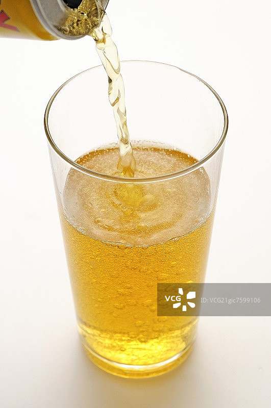 将能量饮料倒入玻璃杯中图片素材