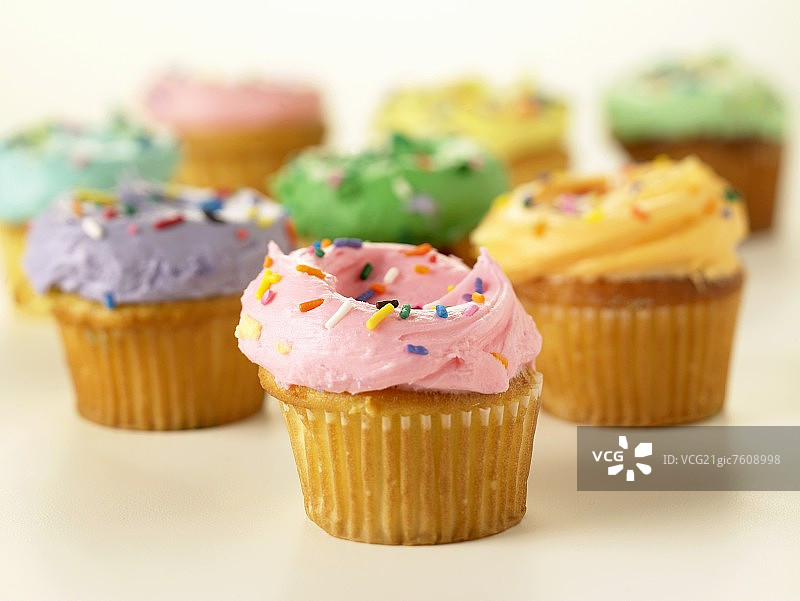 黄色纸杯蛋糕，搭配彩色糖霜和糖粒图片素材