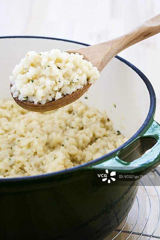 从荷兰烤箱中舀出的烤意大利调味饭图片素材