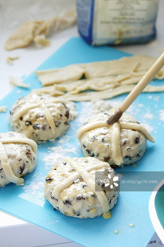 在十字面包上刷蛋液图片素材