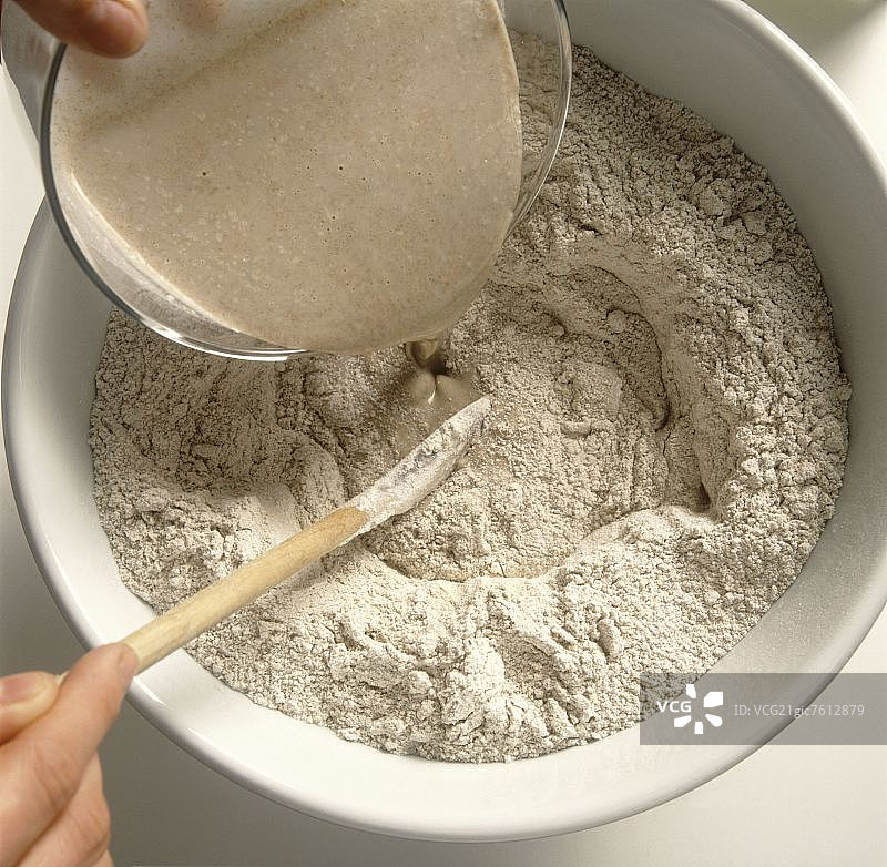 准备酸面包：将酵母倒入面粉中图片素材