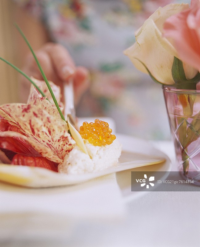 品尝菊苣沙拉上的烟熏三文鱼慕斯的女人图片素材