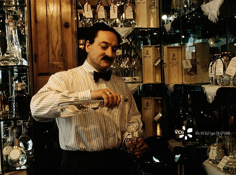 服务员将格拉帕酒倒入玻璃杯中图片素材