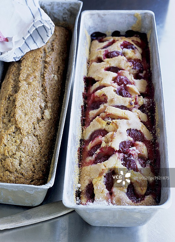两个长方形烤盘里的香蕉蛋糕和李子蛋糕图片素材