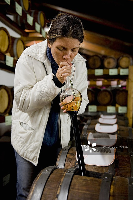 用玻璃器具从桶中吸出香醋图片素材