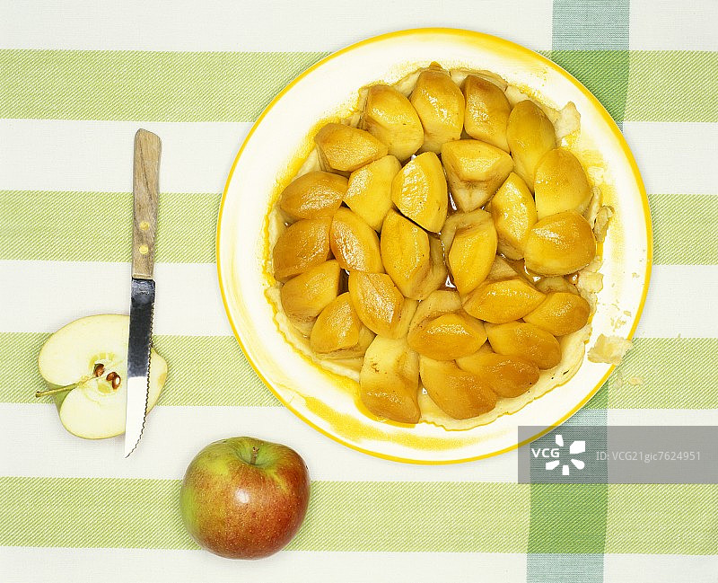 盘子里的反烤苹果塔、刀和新鲜苹果图片素材