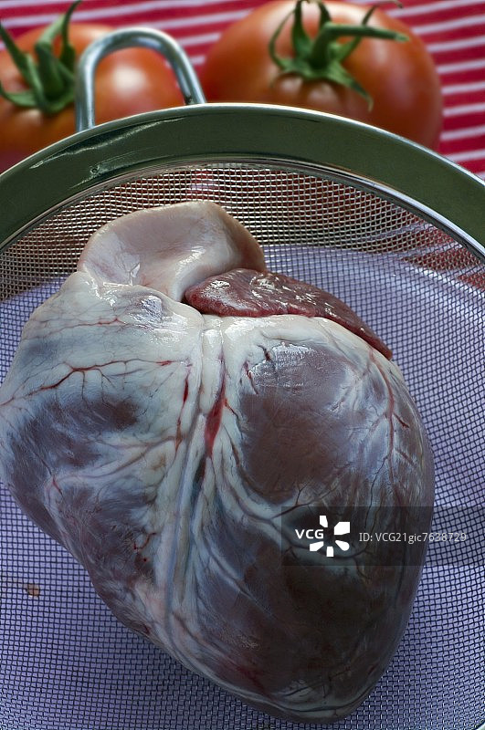 筛子里的生牛心，背景是番茄图片素材
