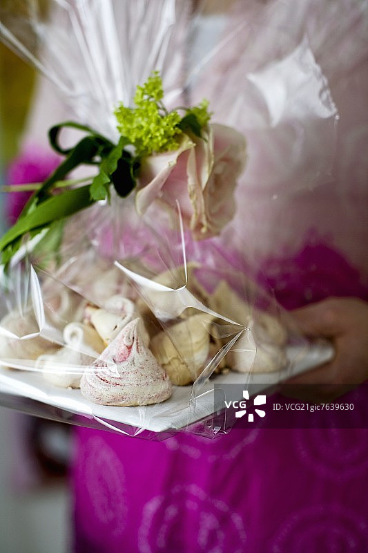 一位女士手持自制蛋白酥皮饼干作为礼物图片素材