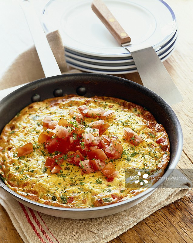 配有新鲜番茄的意大利烘蛋和锅铲图片素材