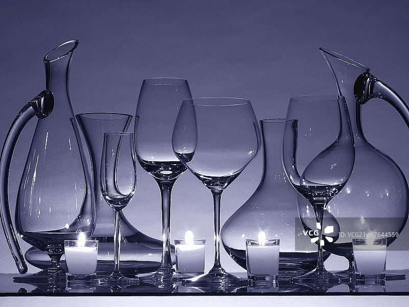 静物：空酒杯、玻璃瓶和蜡烛图片素材