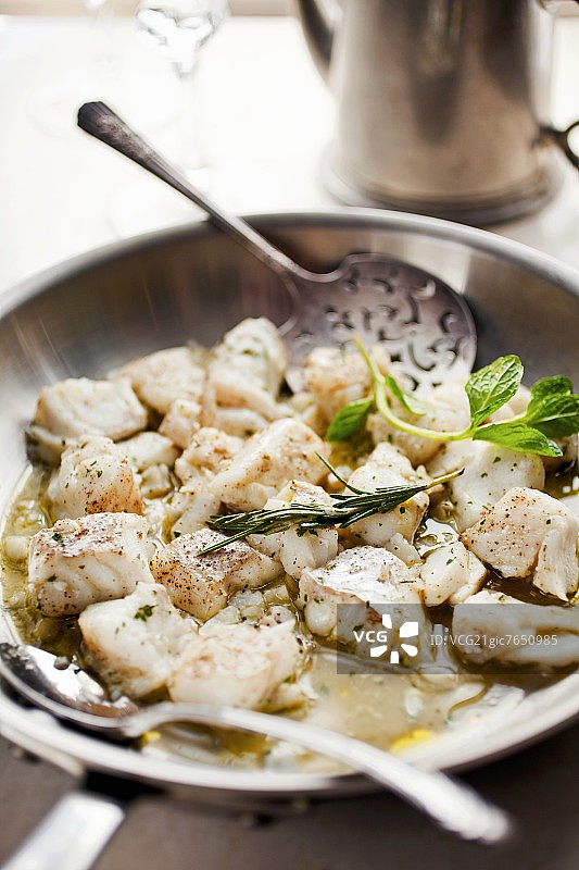 煎锅大比目鱼配勺子图片素材