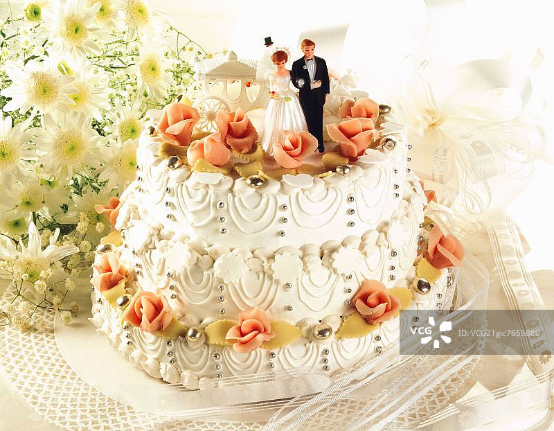 带有新娘和新郎人物的三层白色婚礼蛋糕图片素材
