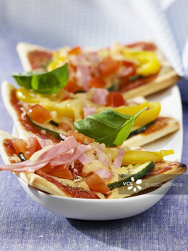 三片披萨加火腿和蔬菜配料图片素材