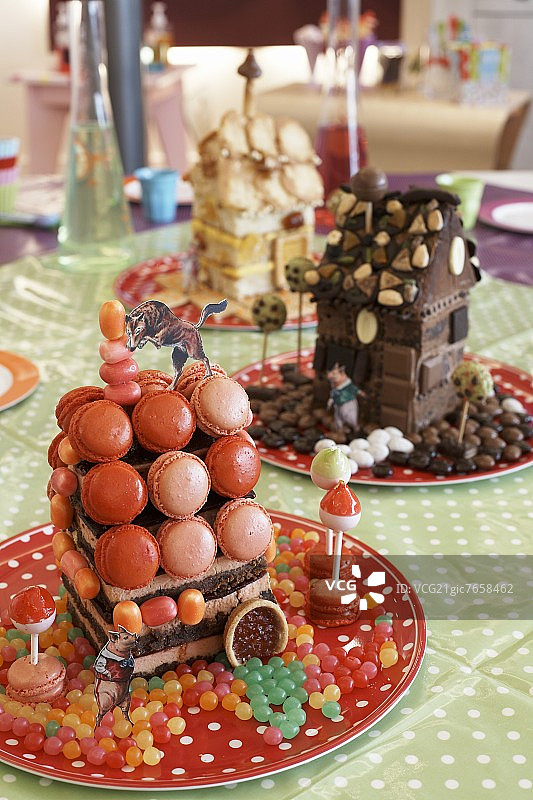 草莓芝士蛋糕和马卡龙制成的小房子图片素材