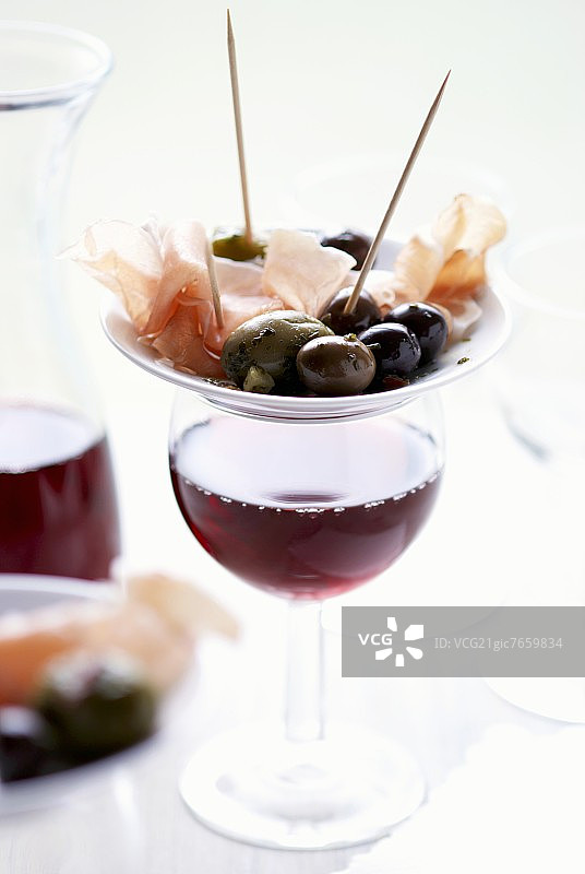 小吃拼盘：橄榄和塞拉诺火腿配红酒图片素材