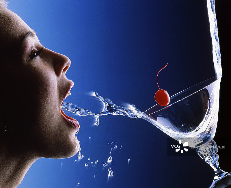 鸡尾酒和鸡尾酒樱桃溅入口中图片素材