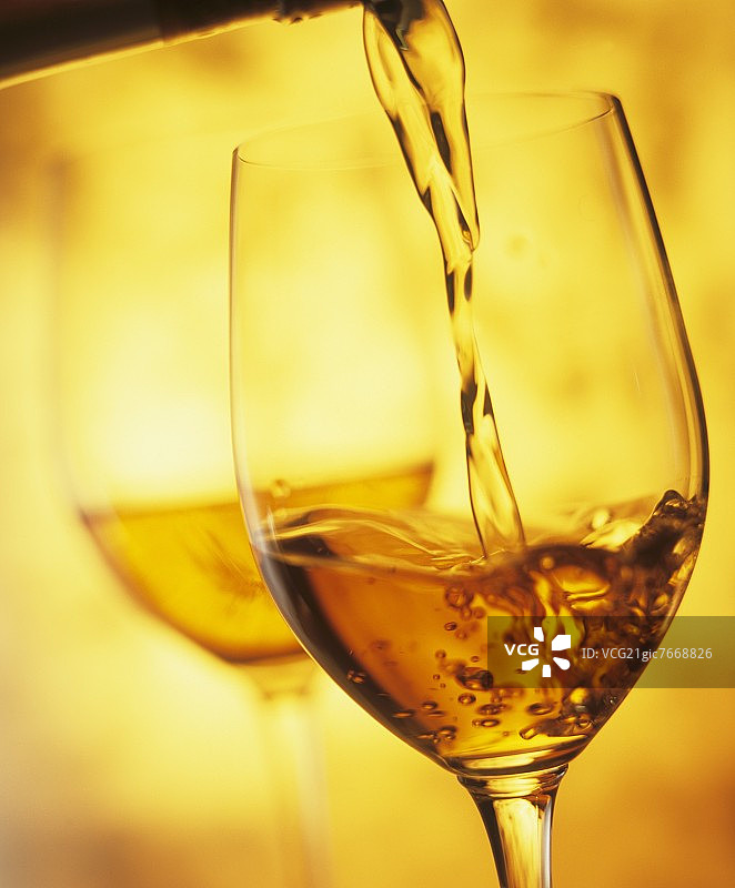将夏朗德松neau（强化葡萄酒）倒入玻璃杯中图片素材