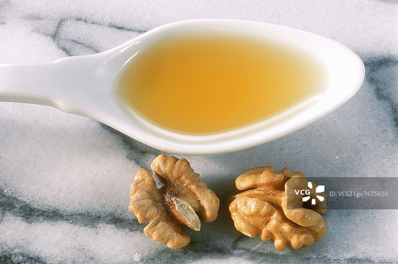 大理石上勺子旁的核桃油和核桃仁图片素材