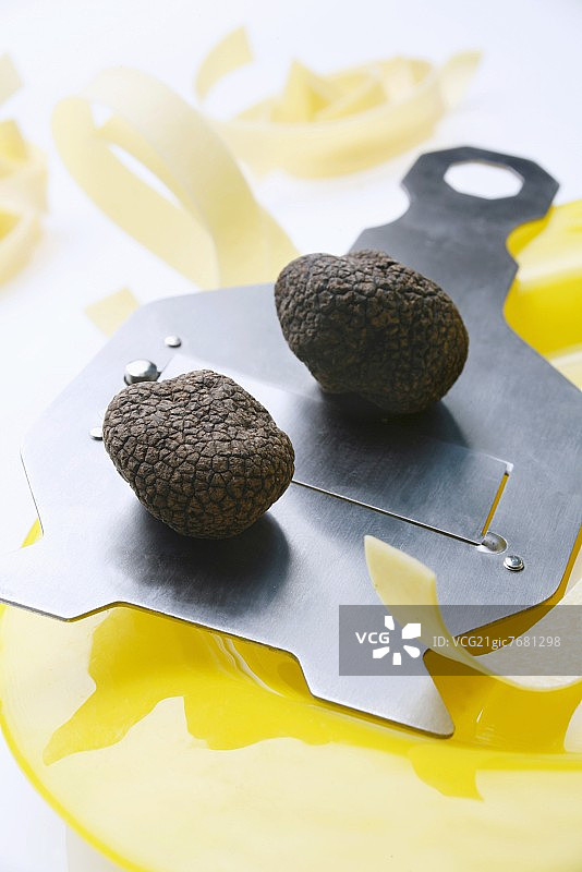 松露切片机上的黑松露（中国松露）和带状意大利面图片素材