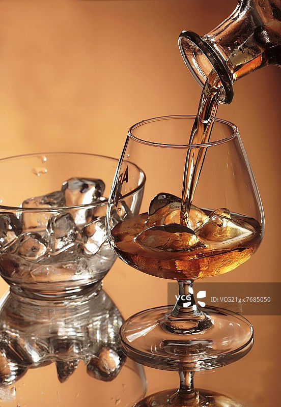 将白兰地倒入装有冰块的玻璃杯中图片素材