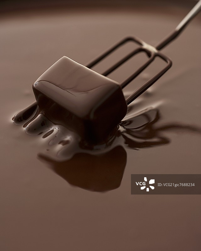 将巧克力蘸入融化的巧克力图片素材