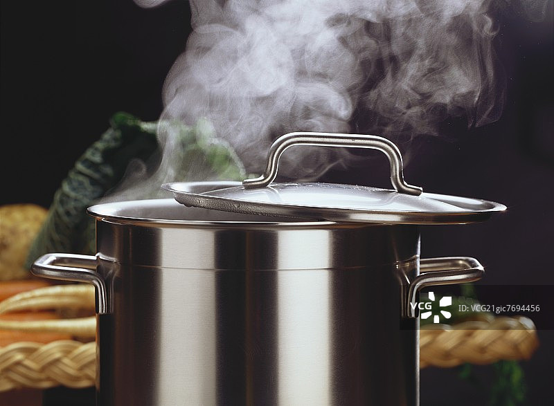 热气腾腾的金属锅，锅盖微开图片素材