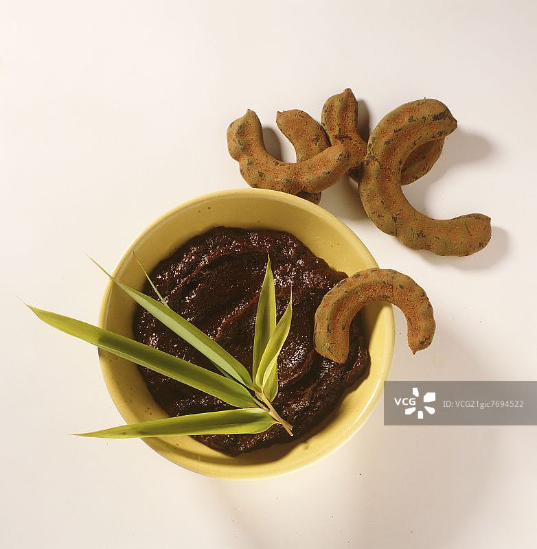 罗望子酱在碗中，旁边是完整的罗望子图片素材