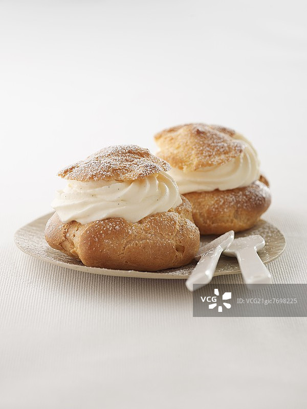盘子里放着两个奶油泡芙图片素材