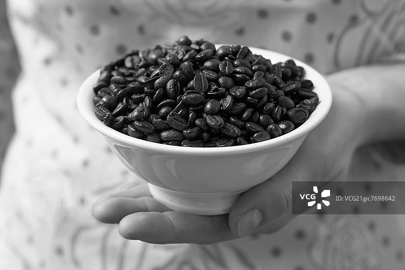 手拿一碗浓缩咖啡豆图片素材