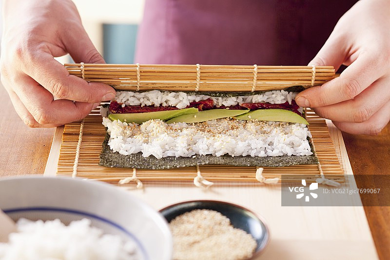 寿司卷的制作过程：竹席卷起图片素材
