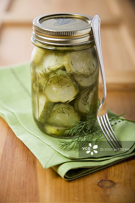 自制新鲜莳萝腌黄瓜罐头与叉子图片素材