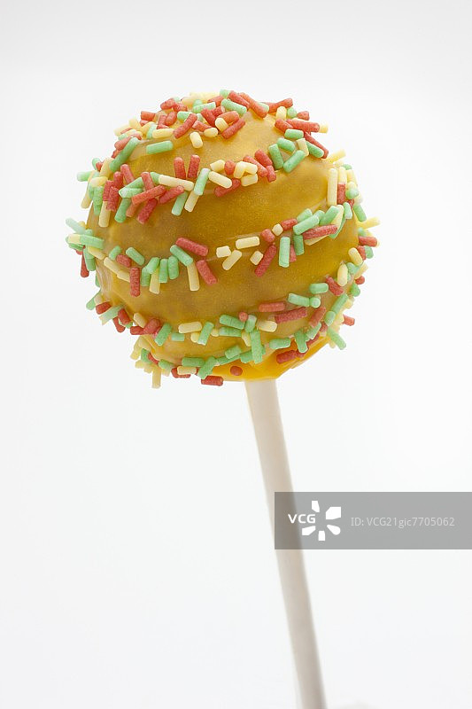 带有彩色糖屑的黄色蛋糕棒棒糖图片素材