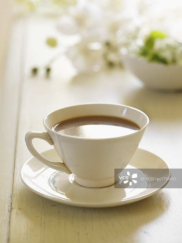 木桌上放着古董杯碟和奶油咖啡图片素材