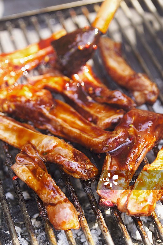 在烧烤架上用腌料刷肋骨图片素材