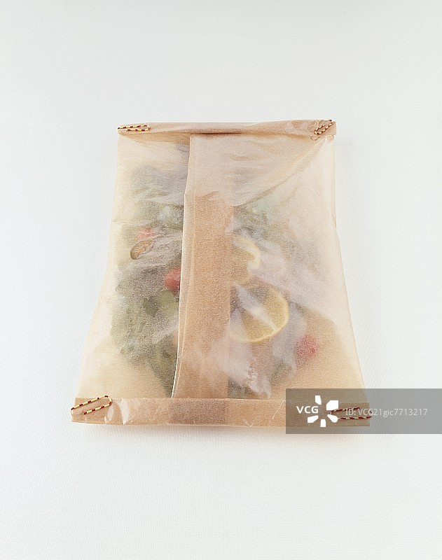 用羊皮纸包裹的海鲈鱼和蔬菜图片素材