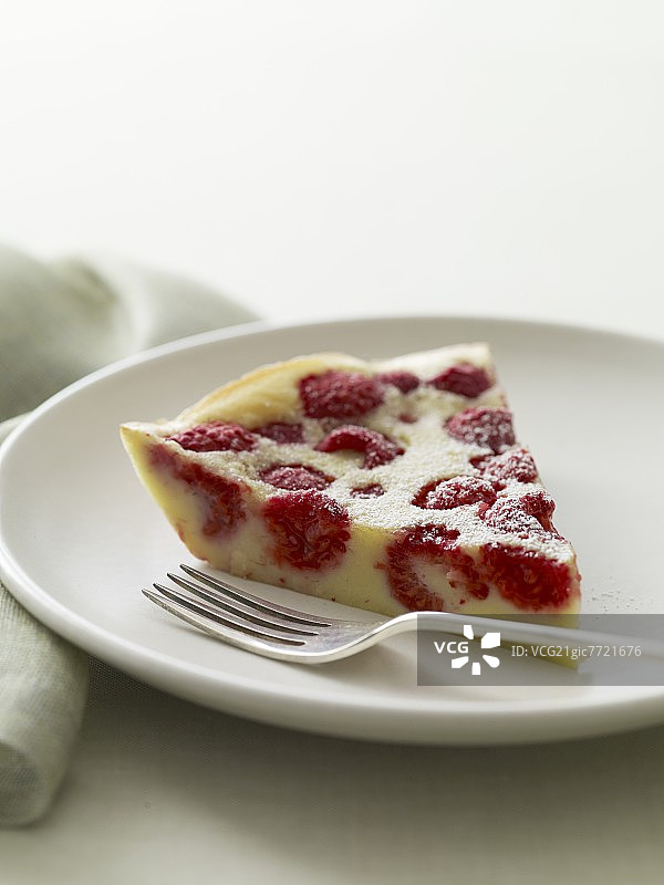 白盘覆盆子蛋糕切片与叉子图片素材