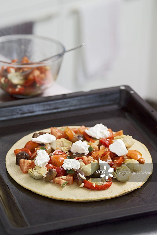 烤盘上未烘烤的素食披萨图片素材