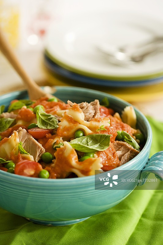 蝴蝶形意大利面配番茄酱、豌豆和罗勒图片素材