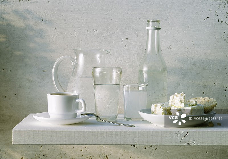 希腊餐桌场景与茴香酒，水，绵羊奶酪和面包图片素材