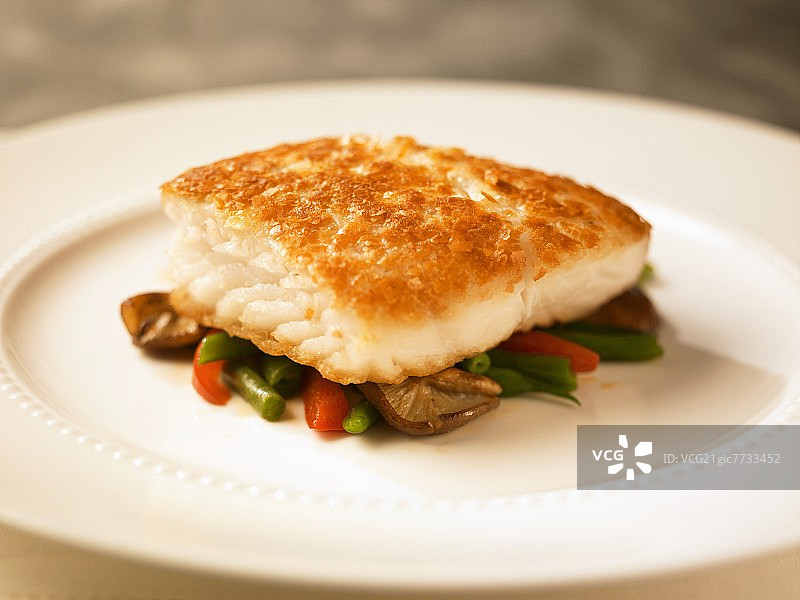 蔬菜床上配马铃薯皮的比目鱼图片素材