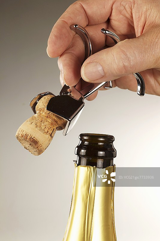 用香槟钳打开气泡酒瓶图片素材