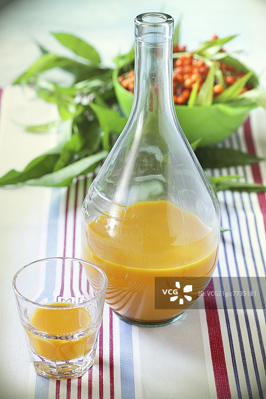 瓶装和玻璃杯中的沙棘汁图片素材
