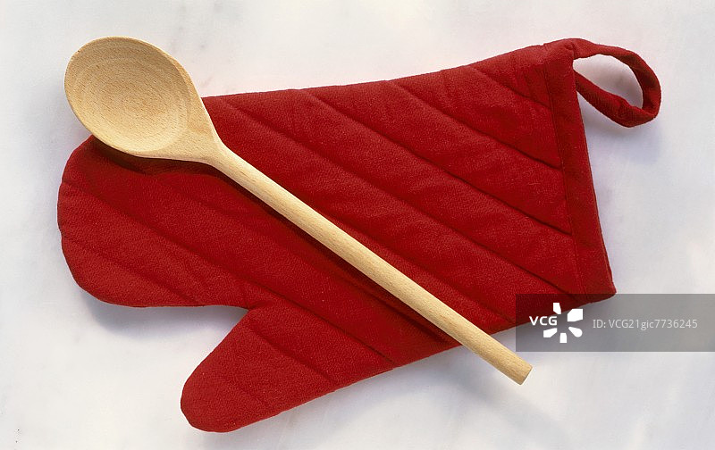 红色烤箱手套上的木勺图片素材