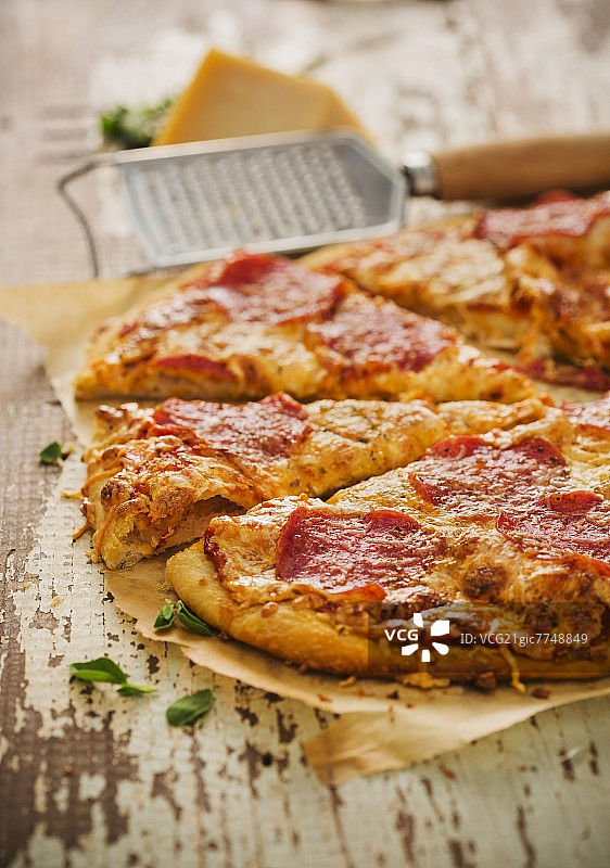 羊皮纸上切片的意大利辣香肠披萨图片素材