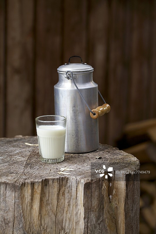 乡村木块上的牛奶桶和牛奶玻璃杯图片素材