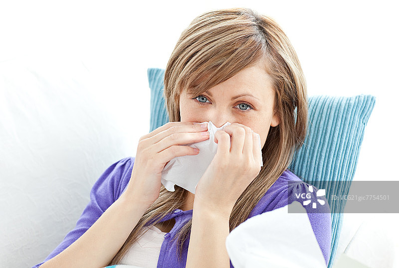 躺在白色背景沙发上，身体不适的美丽女人肖像图片素材