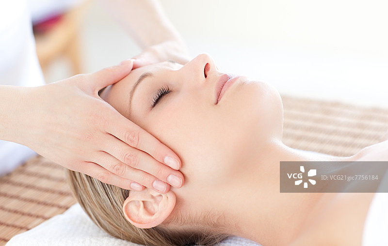 明亮女子在水疗中心接受头部按摩特写图片素材