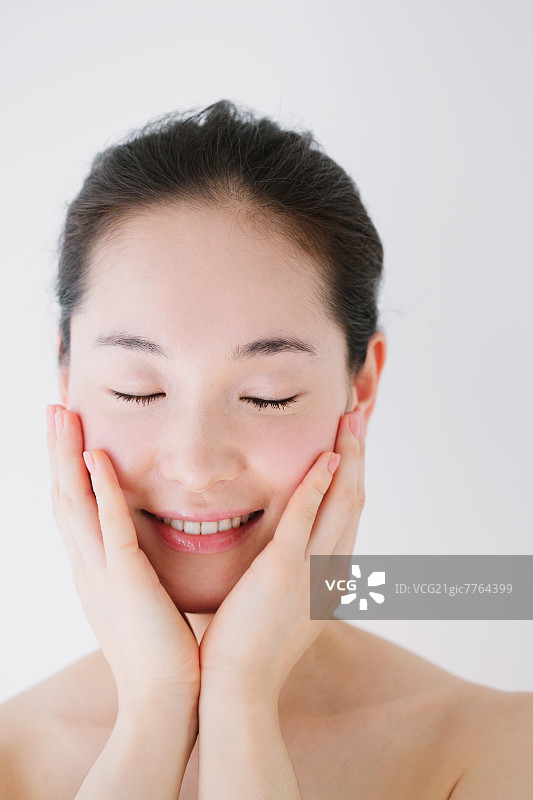 闭着眼睛微笑的素颜年轻女人图片素材